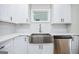 Bright kitchen features white cabinets, stainless steel appliances, undermount sink, and stylish backsplash at 809 Dill Sw Ave, Atlanta, GA 30310