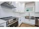 Close-up of kitchen with stainless steel appliances, white cabinets, and unique backsplash tile at 809 Dill Sw Ave, Atlanta, GA 30310