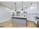 Modern kitchen boasts an island, stainless appliances, white cabinets, and hardwood floors at 809 Dill Sw Ave, Atlanta, GA 30310