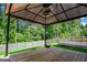 A detailed gazebo sits on a wood platform in the spacious backyard with a privacy fence at 411 Hopi Ln, Villa Rica, GA 30180