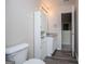 Bathroom with wood-look floors, granite vanity, toilet and cabinet storage next to a vanity mirror at 411 Hopi Ln, Villa Rica, GA 30180