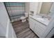 Bathroom featuring wood-look floor, granite vanity, toilet, tub, and shower with striped curtain at 411 Hopi Ln, Villa Rica, GA 30180