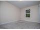 Neutral carpeted bedroom featuring a large window at 411 Hopi Ln, Villa Rica, GA 30180