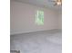 A bright bedroom featuring a large window and neutral-toned carpet at 411 Hopi Ln, Villa Rica, GA 30180