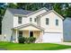 Charming two-story home featuring a covered porch, two-car garage, and well-maintained lawn at 411 Hopi Ln, Villa Rica, GA 30180