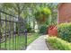 View of a well-manicured backyard with a walkway to a deck, as seen through an open wrought iron gate at 821 Carnellian Ln, Peachtree City, GA 30269