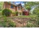 Brick home featuring a deck, covered patio, and a yard with foliage and mature trees at 821 Carnellian Ln, Peachtree City, GA 30269