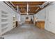Spacious basement area with exposed ceiling, shelving, cabinets, and potential for various uses at 821 Carnellian Ln, Peachtree City, GA 30269