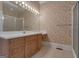 Bathroom featuring wallpaper, vanity with drawers, sink, mirror, and shower with glass door at 821 Carnellian Ln, Peachtree City, GA 30269