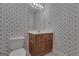 Cozy bathroom featuring floral wallpaper, a wooden vanity, and a toilet at 821 Carnellian Ln, Peachtree City, GA 30269