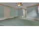 Large bedroom with light-blue walls, carpet flooring, ceiling fan and a view into the bathroom at 821 Carnellian Ln, Peachtree City, GA 30269