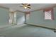 Spacious bedroom with light-blue walls, carpet flooring, a ceiling fan and two windows at 821 Carnellian Ln, Peachtree City, GA 30269