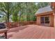 Expansive stained deck featuring a grill, wood railings, brick exterior of the home and backyard at 821 Carnellian Ln, Peachtree City, GA 30269