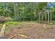 Backyard garden area with a wood trellis, foliage, brick border, and fencing at 821 Carnellian Ln, Peachtree City, GA 30269