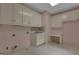 Laundry room with white cabinets and sink, light pink walls and white tile floors at 821 Carnellian Ln, Peachtree City, GA 30269
