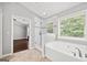 Bright bathroom showcasing a soaking tub, tiled shower, and a view to the bedroom at 1220 Roswell Manor Cir, Roswell, GA 30076