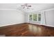 Spacious bedroom featuring hardwood floors, large windows, and modern ceiling fan at 1220 Roswell Manor Cir, Roswell, GA 30076