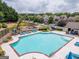 Community pool with sun loungers, surrounded by lush landscaping and a playground in a beautiful neighborhood at 1220 Roswell Manor Cir, Roswell, GA 30076