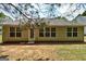 Back exterior with well-maintained siding, a few windows, and a well-manicured lawn at 2504 Plymouth Way, Conyers, GA 30013