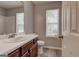 Bathroom features a white sink and vanity, window with blinds, and wood-look flooring at 2504 Plymouth Way, Conyers, GA 30013