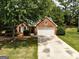 Charming brick home with a two-car garage, well-manicured lawn, and mature trees at 2504 Plymouth Way, Conyers, GA 30013
