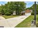 Residential street view of a one-story brick home with two-car garage, spacious front yard, and mature shade trees at 2504 Plymouth Way, Conyers, GA 30013
