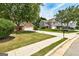 View of the brick home with a lush green lawn, long driveway, and neighboring homes in a residential area at 2504 Plymouth Way, Conyers, GA 30013