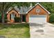Charming one-story brick home featuring a well-manicured lawn, two-car garage, and inviting front entrance at 2504 Plymouth Way, Conyers, GA 30013