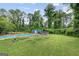 Backyard pool with concrete deck, lawn, shed and trees at 962 Brighton Dr, Lawrenceville, GA 30043