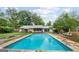 Backyard pool with concrete deck, patio, screened porch, and trees at 962 Brighton Dr, Lawrenceville, GA 30043