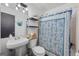 Small bathroom featuring a pedestal sink and blue patterned shower curtain at 962 Brighton Dr, Lawrenceville, GA 30043
