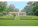 Backyard features home, garden beds, lush lawn, and privacy-enhancing trees, perfect for outdoor enjoyment at 210 Grandchester Way, Fayetteville, GA 30215