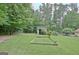 Backyard with storage building, garden beds, and mature trees, perfect for outdoor activities and gardening at 210 Grandchester Way, Fayetteville, GA 30215