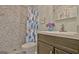 Bathroom featuring a vanity with dark brown cabinets and shower with decorative tile at 210 Grandchester Way, Fayetteville, GA 30215