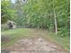 Exterior featuring a long driveway leading to a house and a border of lush trees at 210 Grandchester Way, Fayetteville, GA 30215