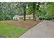 View of ranch home from a driveway with a backdrop of mature trees and natural surroundings at 210 Grandchester Way, Fayetteville, GA 30215