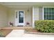 Covered front porch with tile flooring, flowers, and a stylish front door at 210 Grandchester Way, Fayetteville, GA 30215