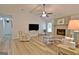Open living room features wood floors, a ceiling fan, and a painted brick fireplace at 210 Grandchester Way, Fayetteville, GA 30215