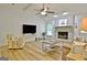 Bright living room with wood floors, ceiling fan, and a white painted fireplace at 210 Grandchester Way, Fayetteville, GA 30215