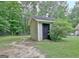 Exterior of storage building with siding, a dark door, and a small bush nearby, perfect for outdoor tools at 210 Grandchester Way, Fayetteville, GA 30215