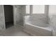 Bathroom featuring elegant marble accents, tub, and shower with glass door at 3368 Alhambra Cir, Hampton, GA 30228