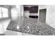 Granite countertops accent dark cabinetry, stainless steel sink, and modern lighting fixtures in the kitchen at 3368 Alhambra Cir, Hampton, GA 30228
