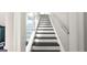 View of modern staircase with black steps, white risers, glass railing, and a metal handrail at 3368 Alhambra Cir, Hampton, GA 30228