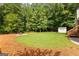 Spacious backyard with mature trees, a storage shed, and a fire pit area, ideal for outdoor activities at 431 Hampton Grn, Peachtree City, GA 30269
