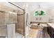 The bathroom features a travertine shower with a glass door, tub, and an arched window at 431 Hampton Grn, Peachtree City, GA 30269