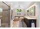 A bathroom with travertine shower, double vanity, and tub with an arched window at 431 Hampton Grn, Peachtree City, GA 30269