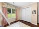 Cozy bedroom featuring hardwood floors, floral valance, large window, and ample closet space at 431 Hampton Grn, Peachtree City, GA 30269