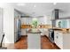 Well-lit kitchen showcasing stainless steel appliances, white cabinetry, an island, and a window at 431 Hampton Grn, Peachtree City, GA 30269