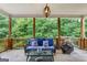 Inviting back porch with comfortable seating, a fire pit, and a view of the lush green trees in the background at 2307 Loughridge Dr, Buford, GA 30519