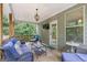Relaxing back porch with comfortable wicker furniture, a TV, and views of the surrounding trees and nature at 2307 Loughridge Dr, Buford, GA 30519